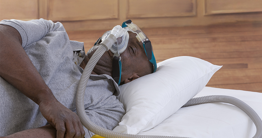 Man sleeping on back with CPAP machine