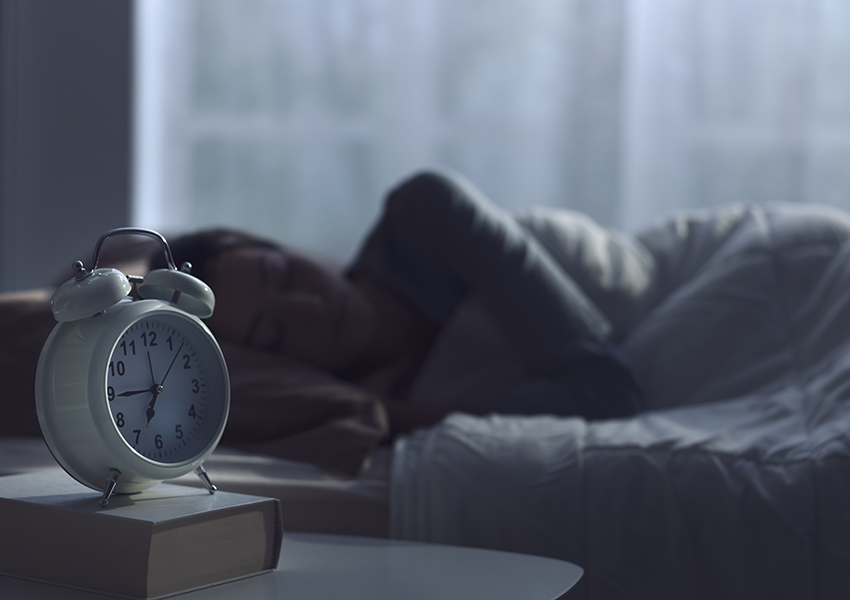 Woman getting deep sleep before alarm clock rings