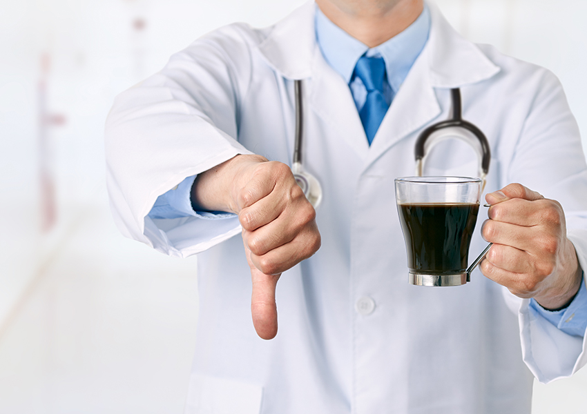 Doctor holding a coffee cup with thumb down