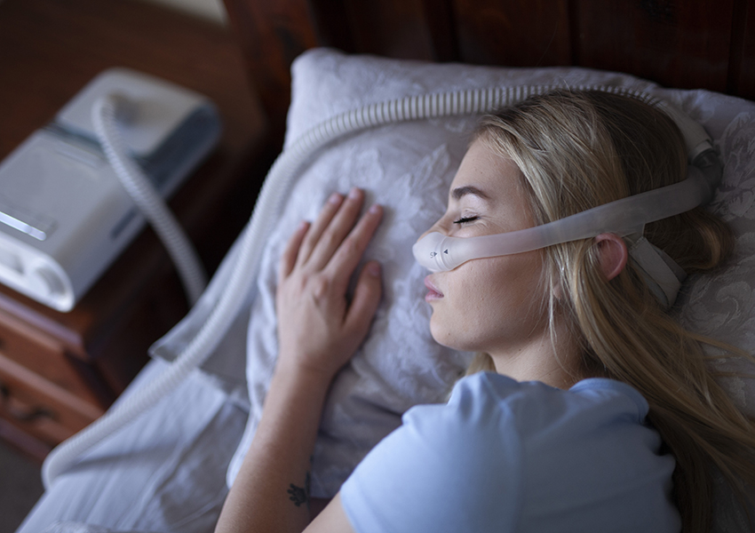 Young person, sleeping with cpap machine.